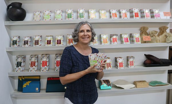 Bryn holding Xocolatísimo chocolate bars in front of shelf