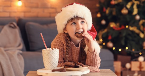 a girl eating a cookie on christmas